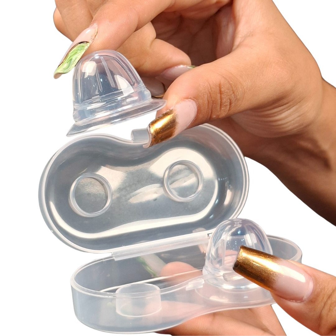 Manos sosteniendo dos saca pezones de silicona transparentes en un estuche, diseñados para corregir pezones planos o invertidos de forma discreta y cómoda.