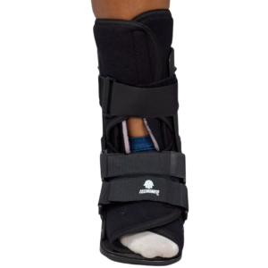Bota ortopédica inmovilizadora (tipo Walker) de la marca Tecnomed, color negro, con correas de ajuste y suela de balancín para rehabilitación de tobillo.