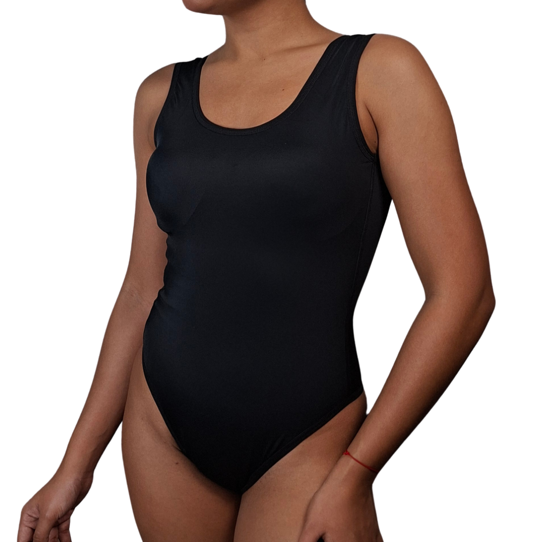 Mujer luciendo el traje de baño entero WAIKIKI (en colores azul, rosa y negro), con escote redondo, espalda baja, faja interna de mediana compresión y copas prehormadas para soporte del busto.