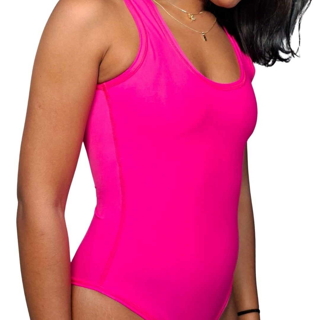 Mujer luciendo el traje de baño entero WAIKIKI (color azul/fucsia), de estilo deportivo con escote en U y espalda nadadora, que incorpora una faja de compresión media para moldear la figura.