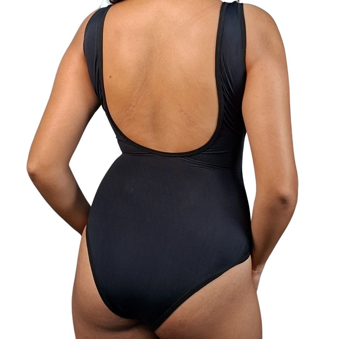 Mujer luciendo el traje de baño entero WAIKIKI (en colores azul, rosa y negro), con escote redondo, espalda baja, faja interna de mediana compresión y copas prehormadas para soporte del busto.