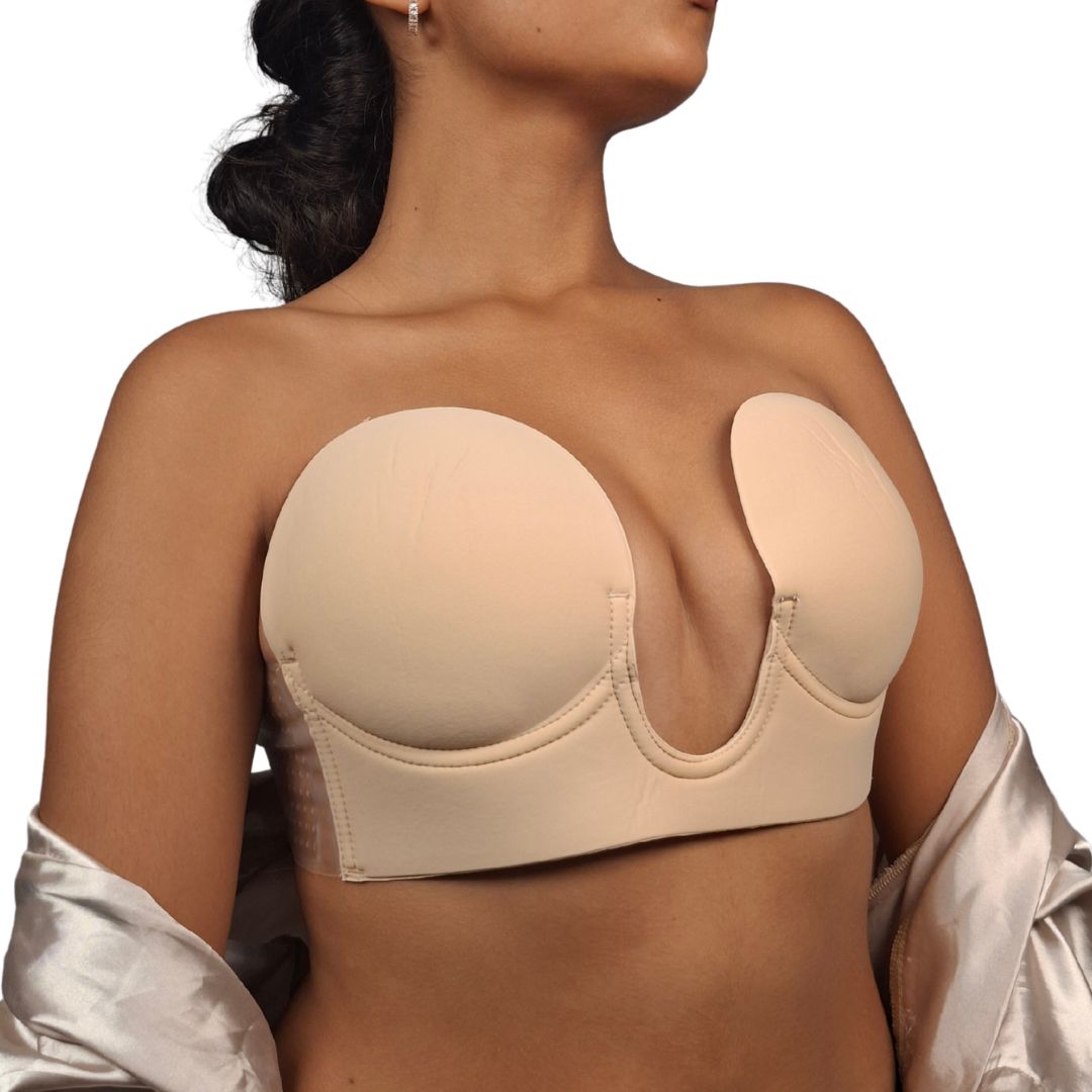 Modelo usando un brasier invisible autoadhesivo de color beige con diseño de escote profundo en forma de U, mostrando el soporte lateral transparente.
