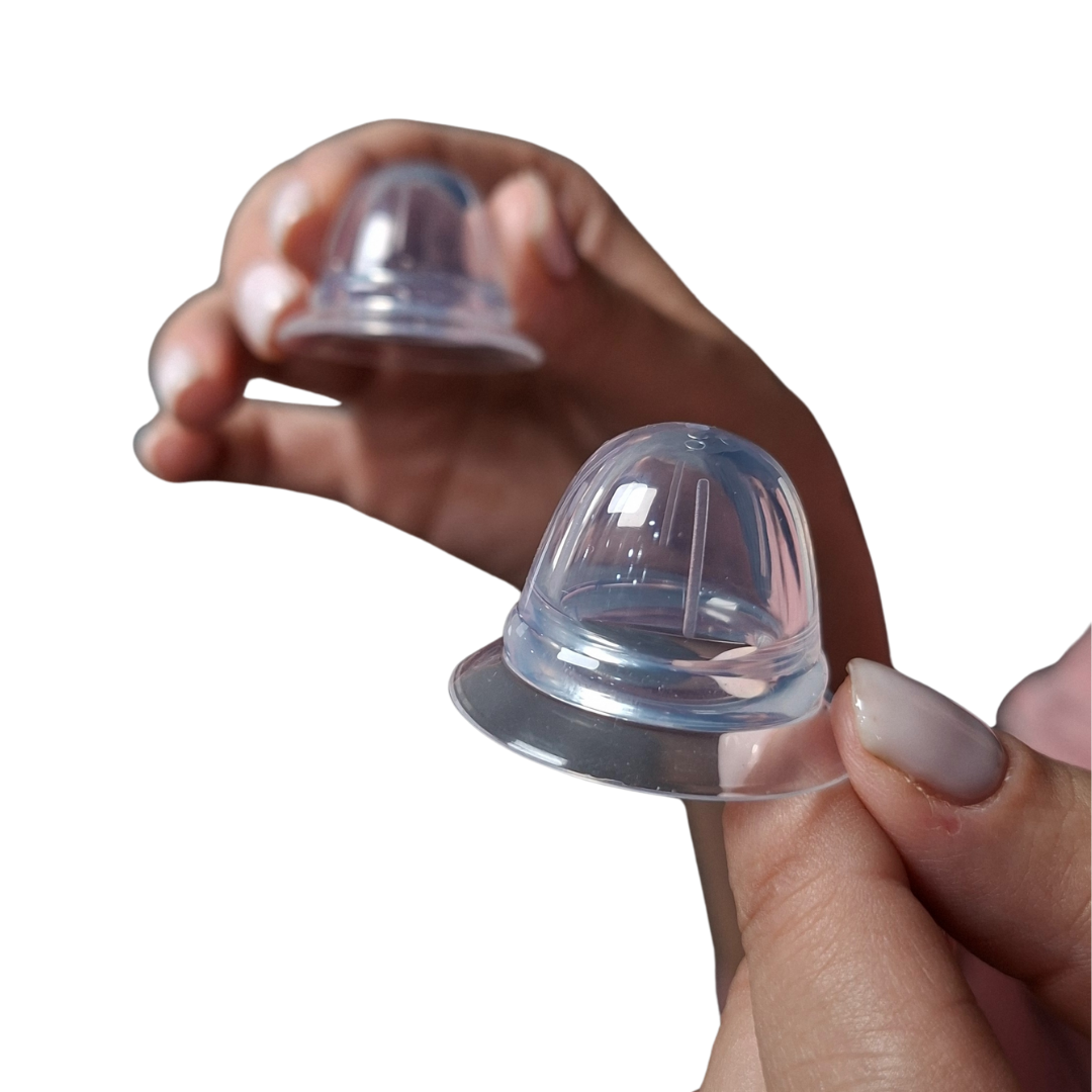 Manos sosteniendo dos saca pezones de silicona transparentes en un estuche, diseñados para corregir pezones planos o invertidos de forma discreta y cómoda.