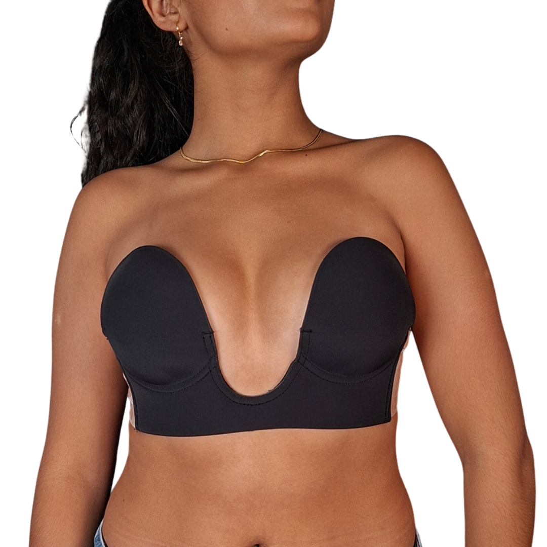 Vista lateral de una mujer utilizando un brasier invisible de color negro con copas preformadas, un pronunciado escote frontal en forma de U y bandas laterales adhesivas de silicona transparente de textura granulada.