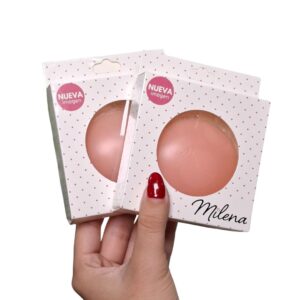 Pezoneras de silicona redondas color piel en su empaque de marca Milena y muestra del adhesivo protector.