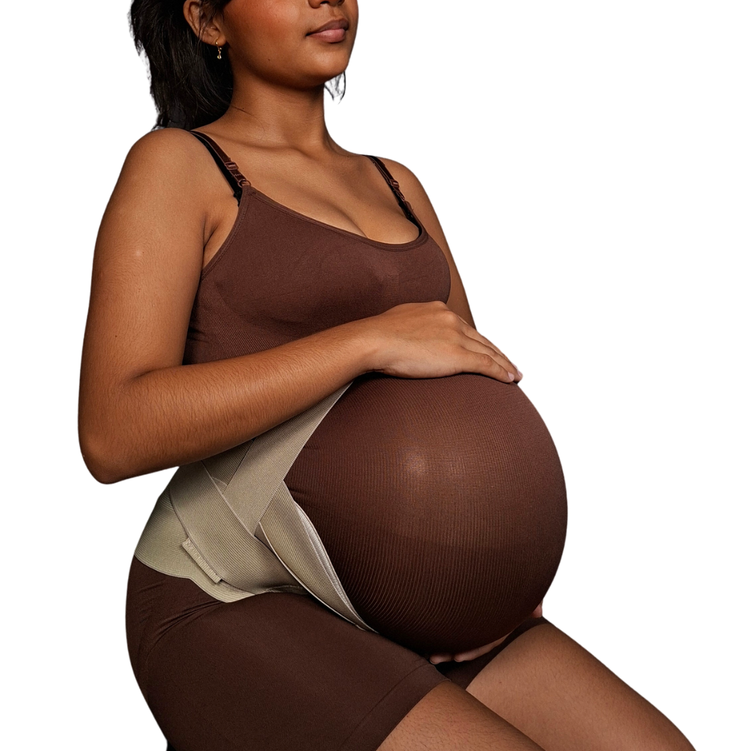 Mujer embarazada utilizando una faja de soporte de maternidad en color beige, con un sistema de bandas elásticas ajustables que elevan el abdomen y brindan soporte a la espalda baja.