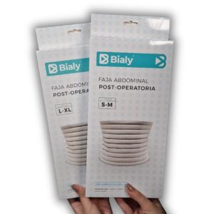 Empaque de la faja abdominal post-operatoria marca Bialy en las tallas S-M y L-XL junto con muestras extendidas de la faja elástica de color beige con cierre de velcro ajustable