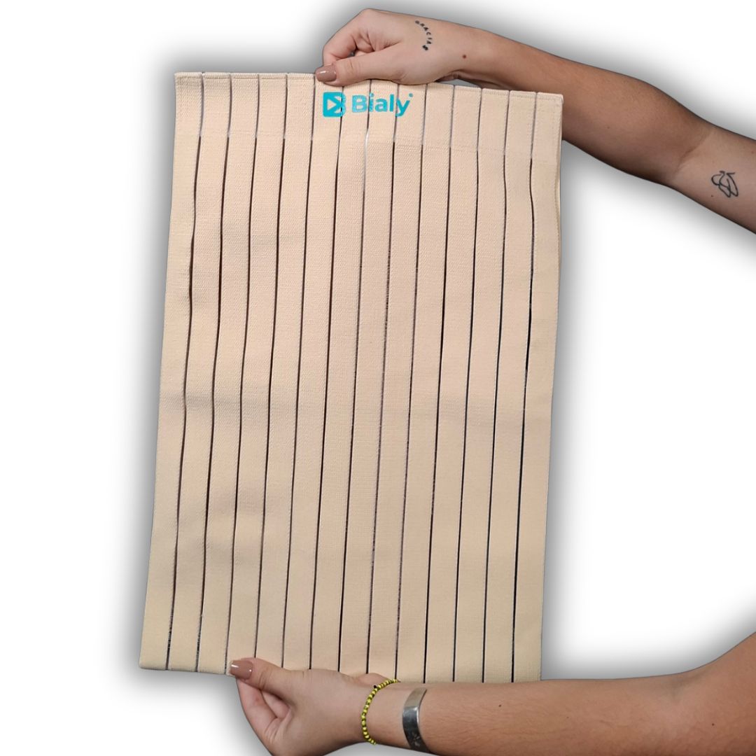 Empaque de la faja abdominal post-operatoria marca Bialy en las tallas S-M y L-XL junto con muestras extendidas de la faja elástica de color beige con cierre de velcro ajustable