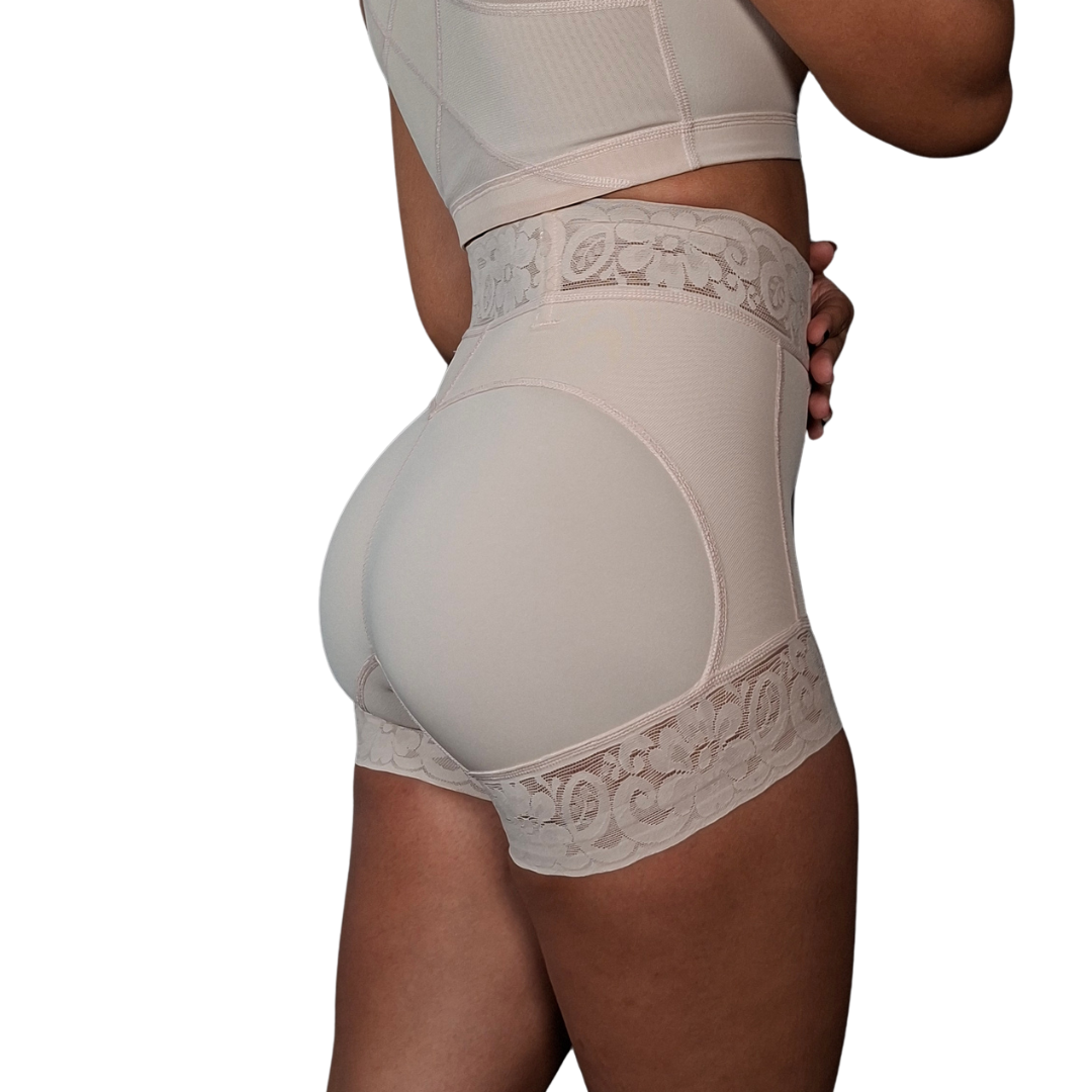 Vista frontal de una prenda de talle alto en tono beige con bandas anchas de encaje floral elástico ubicadas en la pretina superior y en el ruedo de los muslos.