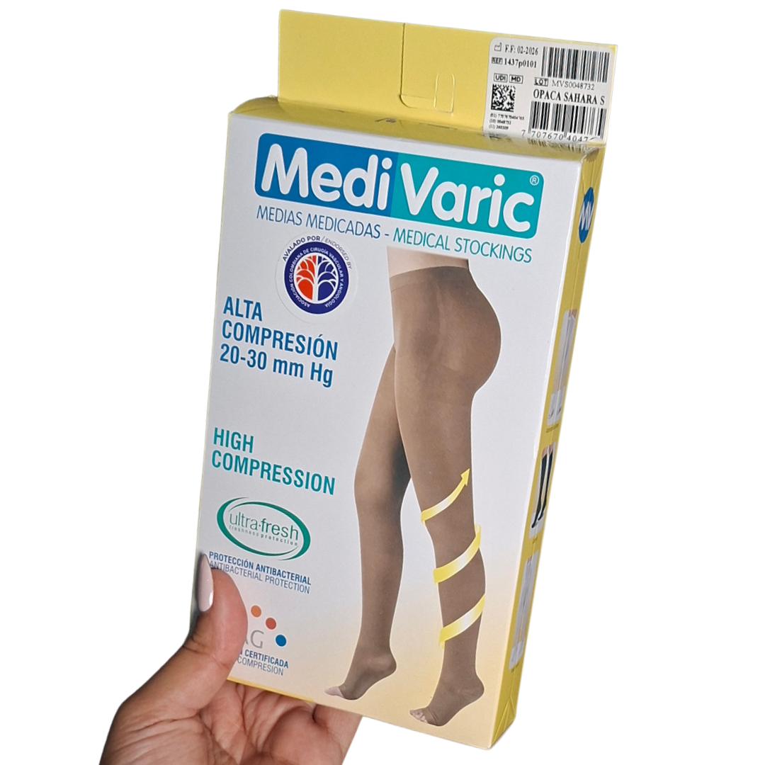 Empaque rectangular de medias medicadas de alta compresión 20-30 mmHg marca MediVaric. Muestra la ilustración del producto cubriendo desde los pies hasta la cadera (tipo pantimedias) en tono beige opaco, con flechas amarillas ascendentes en la pierna que representan la gradiente de compresión vascular y detalle de puntera abierta.