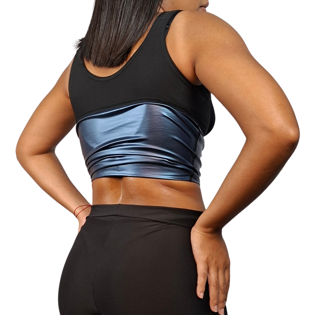 Vista posterior de una mujer luciendo un chaleco deportivo de color negro, mostrando el pliegue del borde inferior con una capa interna metalizada de color azul brillante.
